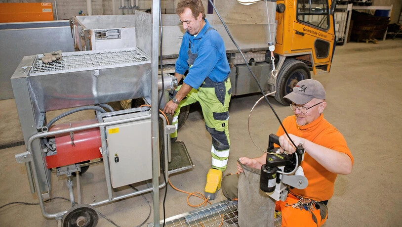 Fredy Braun von der Feuerwehr Glarus füllt zusammen mit einem Mitarbeiter des Werkhofs Sandsäcke im Depot im Buchholz.