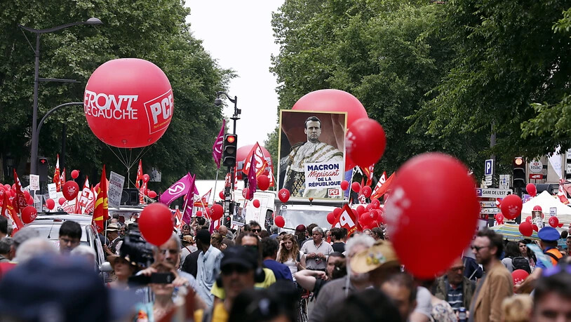 Bunter Demonstrationszug in Paris, mit einer Darstellung Macrons als Kaiser.