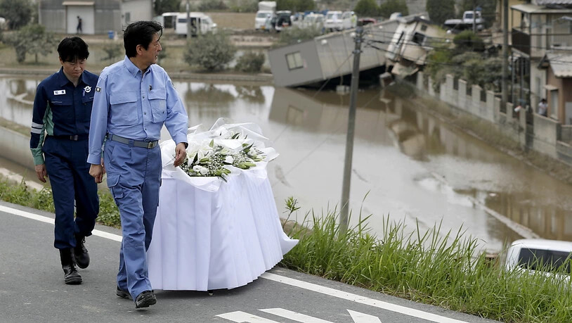 Ministerpräsident Shinzo Abe bei einem Besuch in den japanischen Überschwemmungsgebieten. (Archiv)