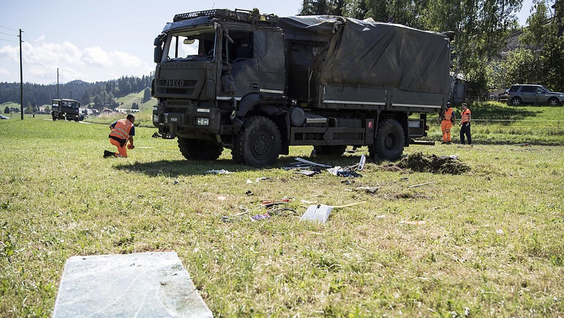 Polizisten untersuchen das in Linden BE verunfallte Transportfahrzeug der Armee, nachdem dieses wieder aufgerichtet worden ist.