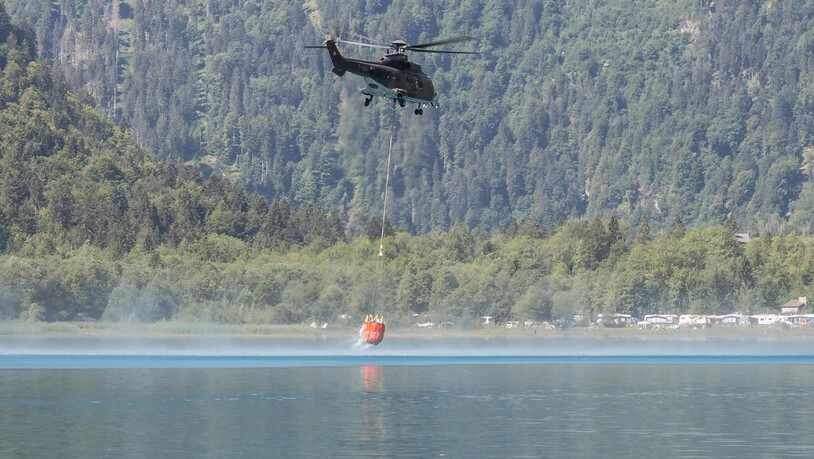 Armee-Helikopter schöpfen Wasser aus dem Klöntalersee, um Landwirte damit zu versorgen.
