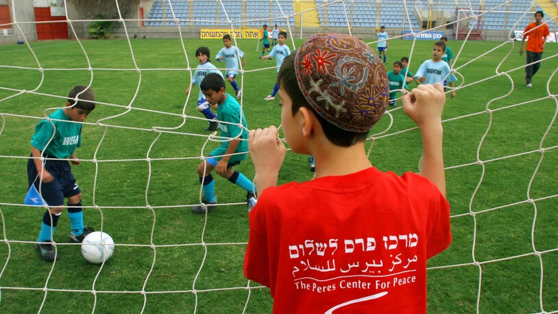Ein israelischer Junge aus der südlichen Stadt Sderot schaut israelischen und palästinensischen Kindern bei einem gemeinsamen Fussballturnier in Herzliya, nördlich von Tel Aviv zu (Symbolbild)