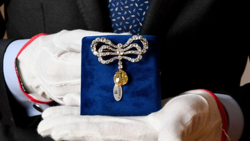 Eine Brosche, die einst im Besitz der französischen Königin Marie-Antoinette war, wird bei einer Präsentation von Juwelen aus dem Haus Bourbon-Parma beim Auktionshaus Sotheby's von einem Mitarbeiter gehalten. Die Versteigerung ist für den 14. November…