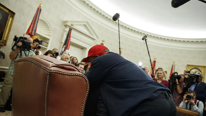 Trump für einmal ganz klein und kaum zu sehen: Der Rapper Kanye West sprang während eines Fototermins im Oval Office auf und umarmte den US-Präsidenten.
