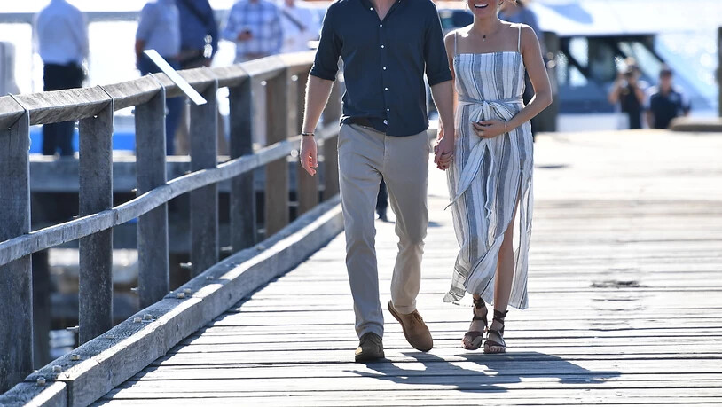Entspannt spazieren Prinz Harry und seine Frau Meghan über eine Mole auf Fraser Island zu einem Treffen mit Fans.
