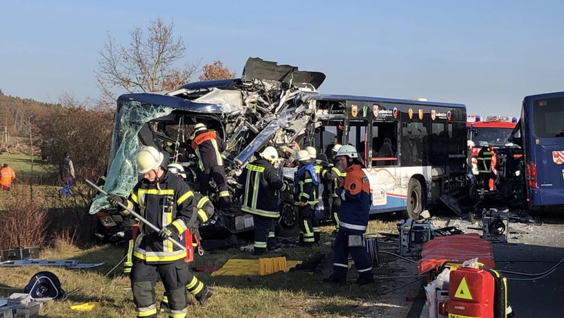 Rettungskräfte arbeiten an der Unfallstelle. Bei dem Zusammenstoss von zwei Schulbussen im Landkreis Fürth sind mehrere Kinder schwer verletzt worden.