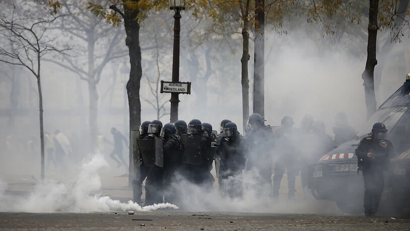 Tränengaseinsatz der Polizei auf den auf den Champs-Elysées in Paris als Aktivisten der "Gelbwesten"-Bewegung bei neuen Protesten eine Sperre durchbrechen wollten.