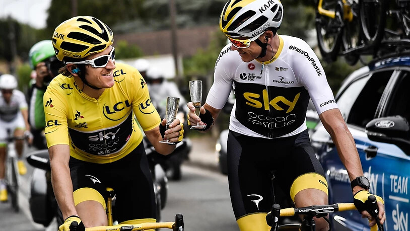 Geraint Thomas (links) und Chris Froome genehmigen sich in der letzten Etappe der Tour de France 2018 ein Glas Sekt. Auch 2019 werden die beiden Briten gemeinsam an der Frankreich-Rundfahrt starten