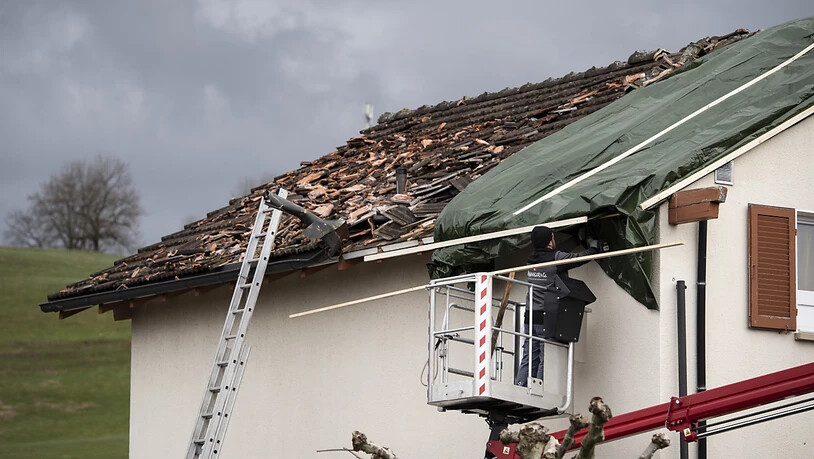 Ein Handwerker repariert ein abgedecktes Dach.