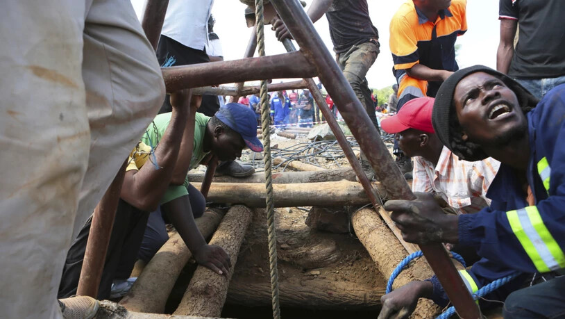 Arbeiter versuchen an einem Eingang der überfluteten Goldmine in Simbabwe, Hilfe für die dutzenden Vermissten zu leisten.