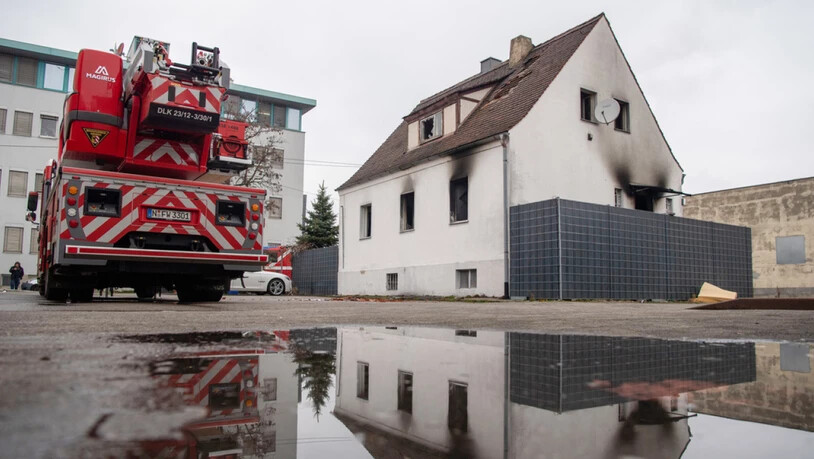 Ein Feuerwehrwagen steht neben einem Haus mit Brandspuren. Bei dem Brand in dem Nürnberger Wohnhaus sind vier Kinder und eine Frau ums Leben gekommen.