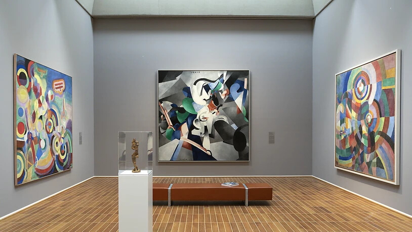 Die Gemälde "Hommage an Blériot" von Robert Delaunay, "Udnie" von Francis Picabia und "Elektrische Prismen" von Sonja Delaunay (von links nach rechts) in der Ausstellung "Kosmos Kubismus. Von Picasso bis Léger" im Kunstmuseum Basel; im Vordergrund der …