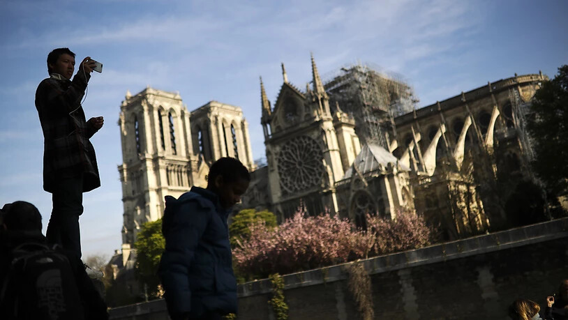 Ein Tourist macht am Mittwoch ein Foto von Notre Dame - Frankreichs Kabinett beriet gleichentags über den Wiederaufbau nach dem Brand der Kathedrale.