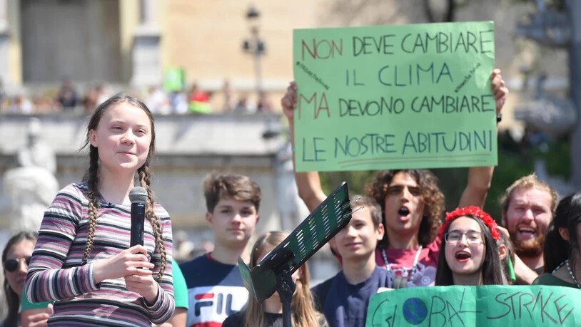 "Nicht das Klima muss sich ändern, aber unsere Gewohnheiten müssen es", halten Klima-Aktivisten in Rom in die Höhe, angeführt von der 16-jährigen Schwedin Greta Thunberg (links, mit Mikrophon).