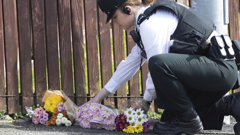 Eine Polizistin legt Blumen nieder, wo die Journalistin Lyra McKee von einer Kugel getroffen wurde und starb. Die Ordnungshüter vermuten, dass katholische Extremisten hinter der Tat stehen.