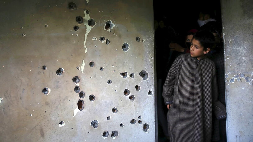 Ein Junge betrachtet die von Kugeln durchlöcherte Wand des Hauses im Süden Srinagars, in sich Zakir Musa verschanzt hatte. A