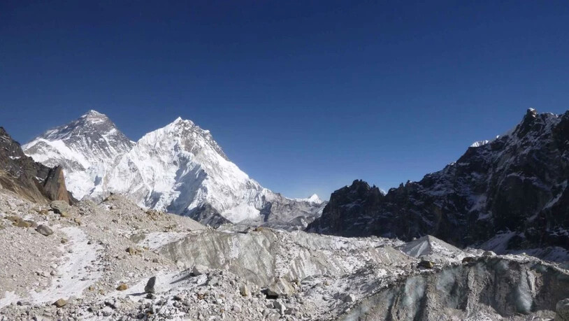 Blick auf den Mount Everest (links im Hintergrund). Im Vordergrund ist der Changri Nup, ein typischer, teils mit Geröll bedeckter Gletscher zu sehen.