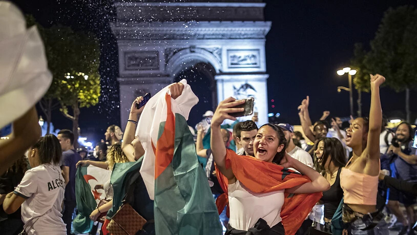 Ausgelassener Jubel: Algerische Fussballfans feiern vor dem Arc de Triomphe in Paris