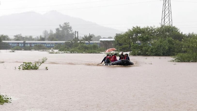 Rettung per Boot: fast 900 Passagiere befanden sich im Südwesten Indiens in einem Zug, der in Monsunfluten stecken blieb.