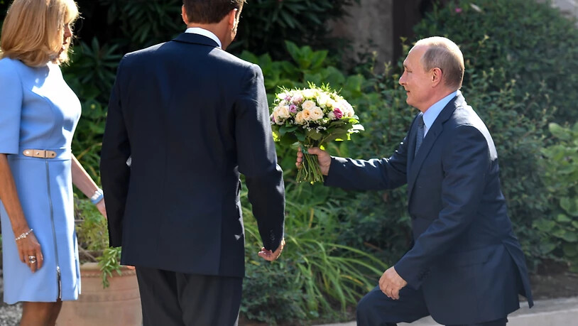 Blumen aus der Hand des russischen Präsidenten Wladimir Putin für die Frau des französischen Präsidenten, Brigitte Macron.