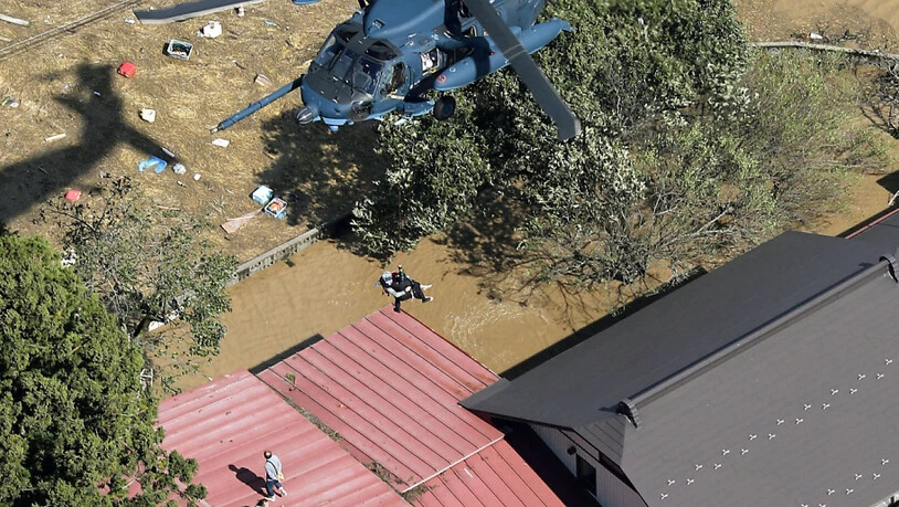 Hausbewohner im Norden Japans bei Marumori flüchteten vor den Wassermassen aufs Dach und warteten auf eine Rettung aus der Luft.
