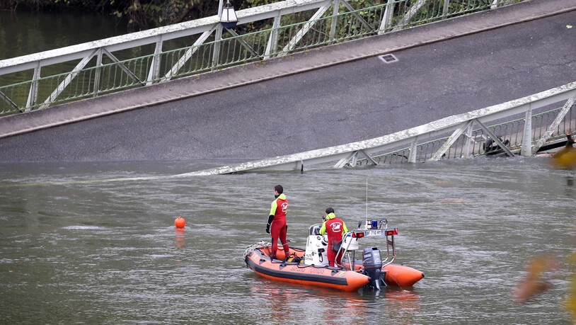 Rettungskräfte suchen im Bereich der eingestürzten Brücke nach Vermissten.