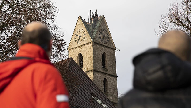 Passanten vor der abgebrannte Spitze des Kirchturms in Herzogenbuchsee.