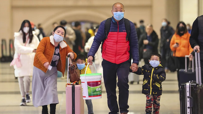 Reisende mit Gesichtsmasken im Bahnhof von Wuhan. Nach neusten Behördenangaben sind bisher 17 Menschen durch das neue Corona-Virus gestorben.