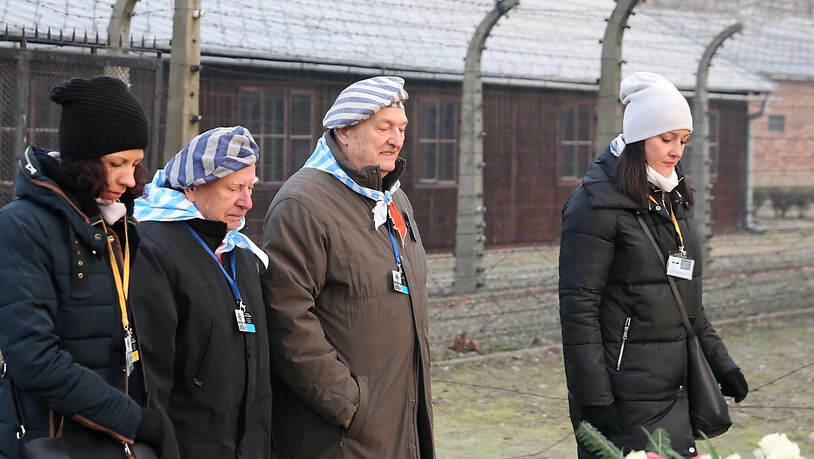 Auschwitz-Überlebende legen im gedenken an die Opfer Kränze nieder.