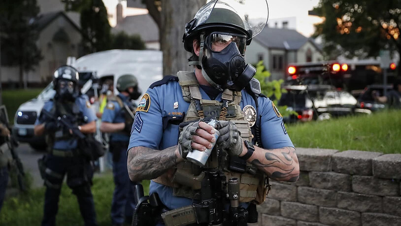 Ein Polizeibeamter mit Gasmaske bereitet sich darauf vor, Tränengas gegen Demonstranten einzusetzen während der Proteste nach dem Tod von George Floyd, der in Folge einer brutalen Festnahme durch einen Polizisten in Minneapolis starb. Ein weißer Polizist…