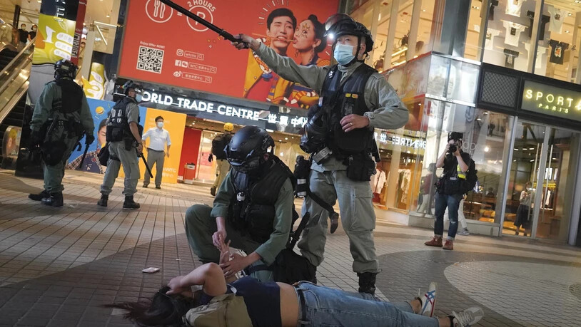 dpatopbilder - Bereitschaftspolizisten verhaftet eine Demonstrantin während einer Demonstration im Einkaufsviertel Causeway Bay. Foto: Vincent Yu/AP/dpa