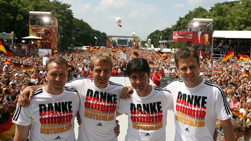 Trotz verpasstem WM-Titel werden Bundestrainer Jürgen Klinsmann, sein Staff und die Spieler vor dem Brandenburger Tor in Berlin von einer halben Million Fans als "Weltmeister der Herzen" gefeiert