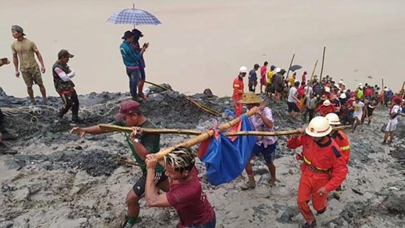 HANDOUT - Rettungskräfte sind nach einem Erdrutsch in einem Jade-Bergwerk in Myanmar im Einsatz. Mindestens 110 Arbeiter sind daei gestorben. Foto: Feuerwehr Myanmar/dpa - ACHTUNG: Nur zur redaktionellen Verwendung im Zusammenhang mit der aktuellen…
