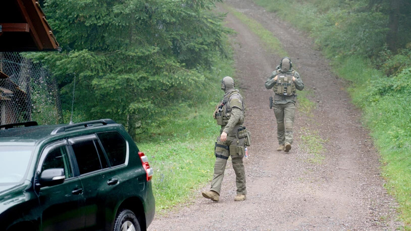 Polizisten gehen bei Oppenau durch ein Waldgebiet.) Foto: Benedikt Spether/dpa