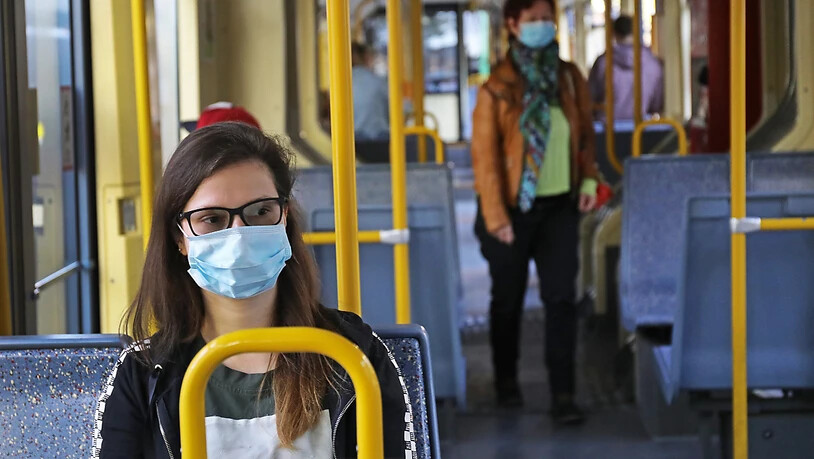 ARCHIV - Fahrgäste sitzen mit Schutzmasken in einer Kölner Straßenbahn. Foto: Oliver Berg/dpa