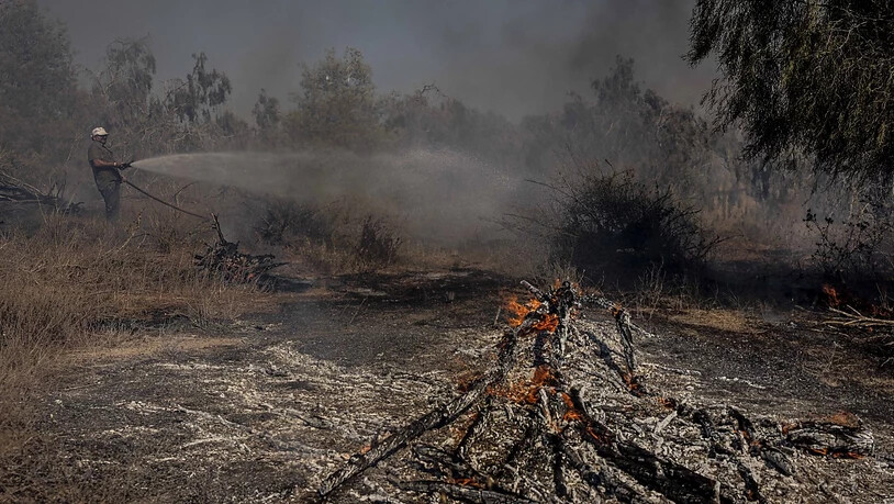 Ein Feuerwehrmann arbeitet bei der Löschung eines Brandes an der israelischen Grenze zum Gazastreifen, der durch einen Brandballon von Palästinensern verursacht wurde. Foto: Tsafrir Abayov/AP/dpa
