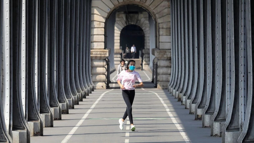 Eine Frau, die eine Schutzmaske trägt, während sie am zwölften Tag einer coronabedingten Abriegelung in Paris joggt. Seit Freitagmorgen (28. August) müssen die Menschen überall in Paris aufgrund er Corona-Pandemie unter freiem Himmel eine Maske tragen…