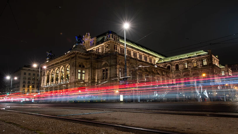 ARCHIV - Die Lichter vorbeifahrender Autos sind vor der Wiener Staatsoper am Abend zu sehen (Langzeitbelichtung). Die Wiener Staatsoper wird am 7. September mit der Premiere von «Madama Butterfly» ihren seit sechs Monaten wegen der Corona-Krise…