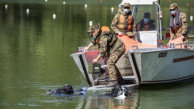 Polizeitaucher übergeben der Schweizer Armee die geborgenen Handgranaten im Rotsee.