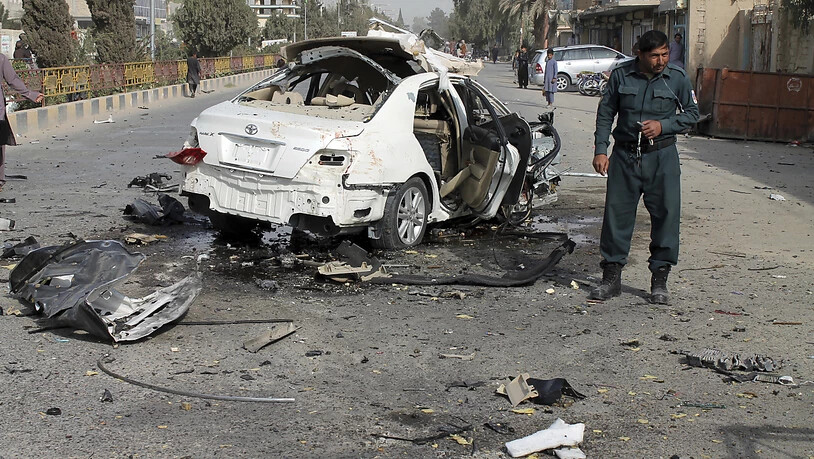 Ein Polizist untersucht ein beschädigtes Auto nach einem Bombenanschlag in der südafghanischen Provinz Helmand. Eine Bombe am Fahrzeug eines Journalisten explodierte am Donnerstag und tötete ihn. Mindestens zwei weitere Menschen, darunter der Bruder des…