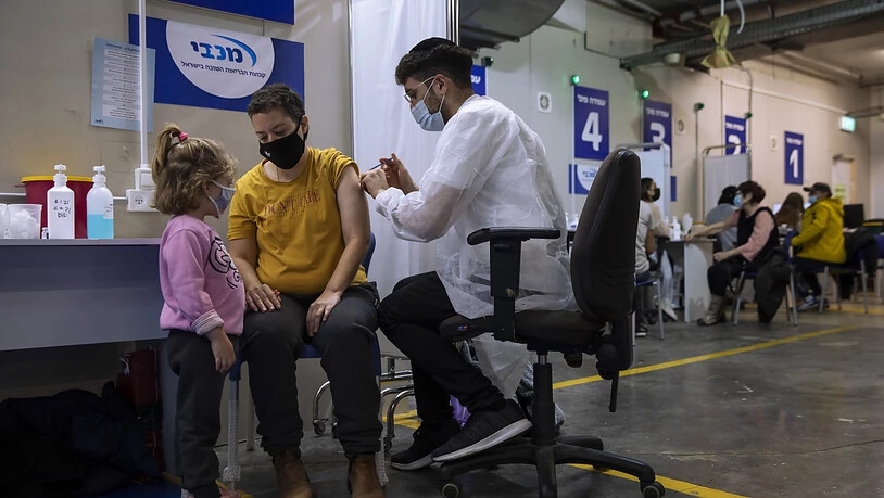 Eine israelische Frau bekommt von einer medizinischen Fachkraft in einem Impfzentrum eine Impfdosis mit dem Corona-Impfstoff von Biontech/Pfizer. Foto: Oded Balilty/AP/dpa
