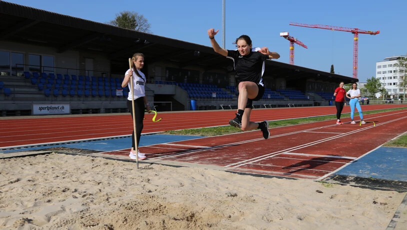 Einblick in die Leichtathletik: Die Teilnehmenden (hier eine junge Frau) bekommen unter den Augen von Annik Kälin (links) die Möglichkeit, sich im Weitsprung zu versuchen.
