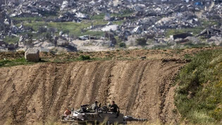 Israelische Soldaten ruhen sich auf ihrem Panzer an der Grenze zum Gazastreifen aus. Foto: Ariel Schalit/AP/dpa