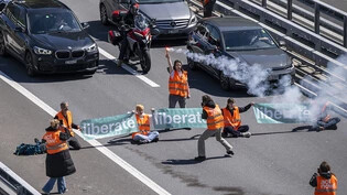 Aktivistinnen und Aktivisten der Klimabewegung Renovate blockieren die Autobahn A2 bei Wassen UR.