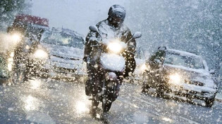 Fahrzeuge kämpfen sich durch das Schneegestöber. Symbolbild/Keystone