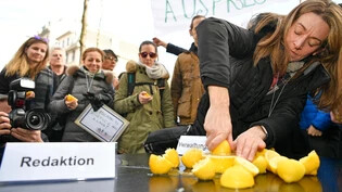 Eine Frau presst symbolisch eine Zitrone aus.