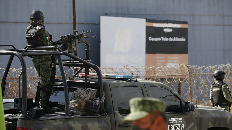Soldaten der mexikanischen Armee stehen vor einem Gefängnis Wache, nachdem eine Bande mehrere Fahrzeuge in das Gefängnis gerammt hat und mit neun Insassen geflohen ist. Foto: Ginnette Riquelme/AP/dpa