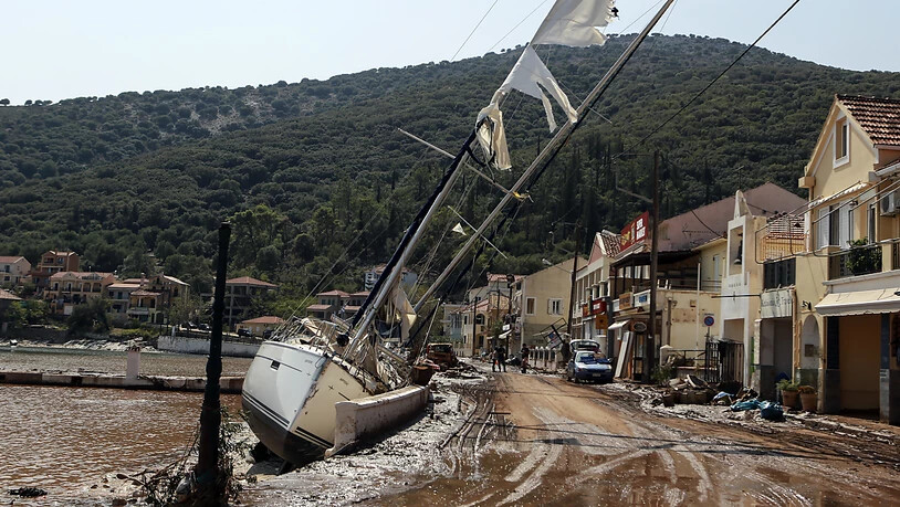Eine Segelyacht liegt nach einem Sturm neben einer Straße an Land. Der Wirbelsturm «Ianos» und ein weiteres Sturmtief über der Nordägäis haben in weiten Teilen Griechenlands schwere Schäden verursacht. Foto: Nikiforos Stamenis/AP/dpa