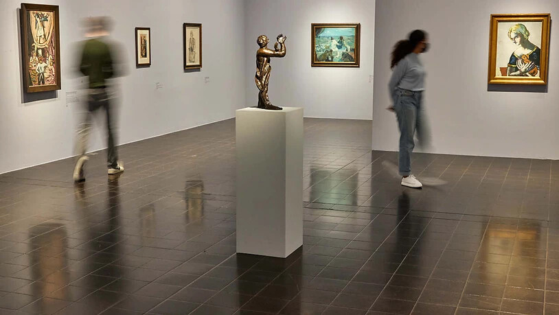 Mitarbeiter gehen während eines Pressetermins in der Kunsthalle durch die Ausstellung «Max Beckmann - weiblich - männlich» (Wischeffekt durch Langzeitbelichtung). Im Vordergrund steht die Bronze-Plastik ""Mann im Dunkeln"" (1934). Foto: Georg Wendt/dpa -…