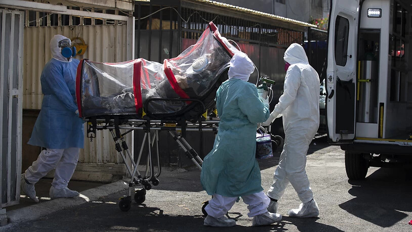 Sanitäter in Schutzanzügen transportieren einen Covid-19-Patienten in Mexiko-Stadt. Foto: Marco Ugarte/AP/dpa